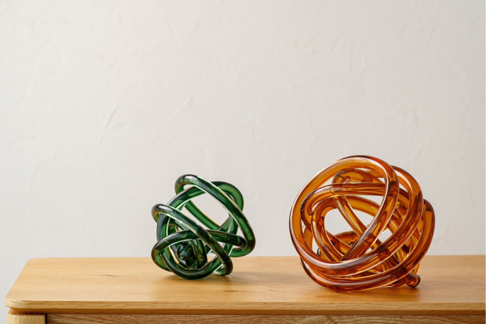 SET OF 2 GLASS PIECES KNOT. AMBER AND GREEN
