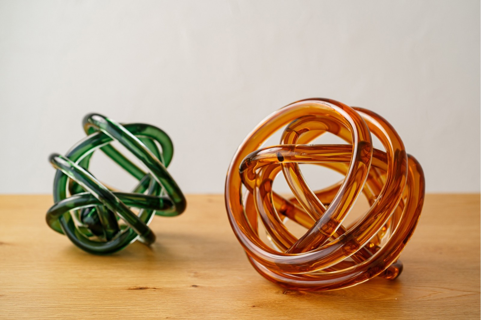 SET OF 2 GLASS PIECES KNOT. AMBER AND GREEN