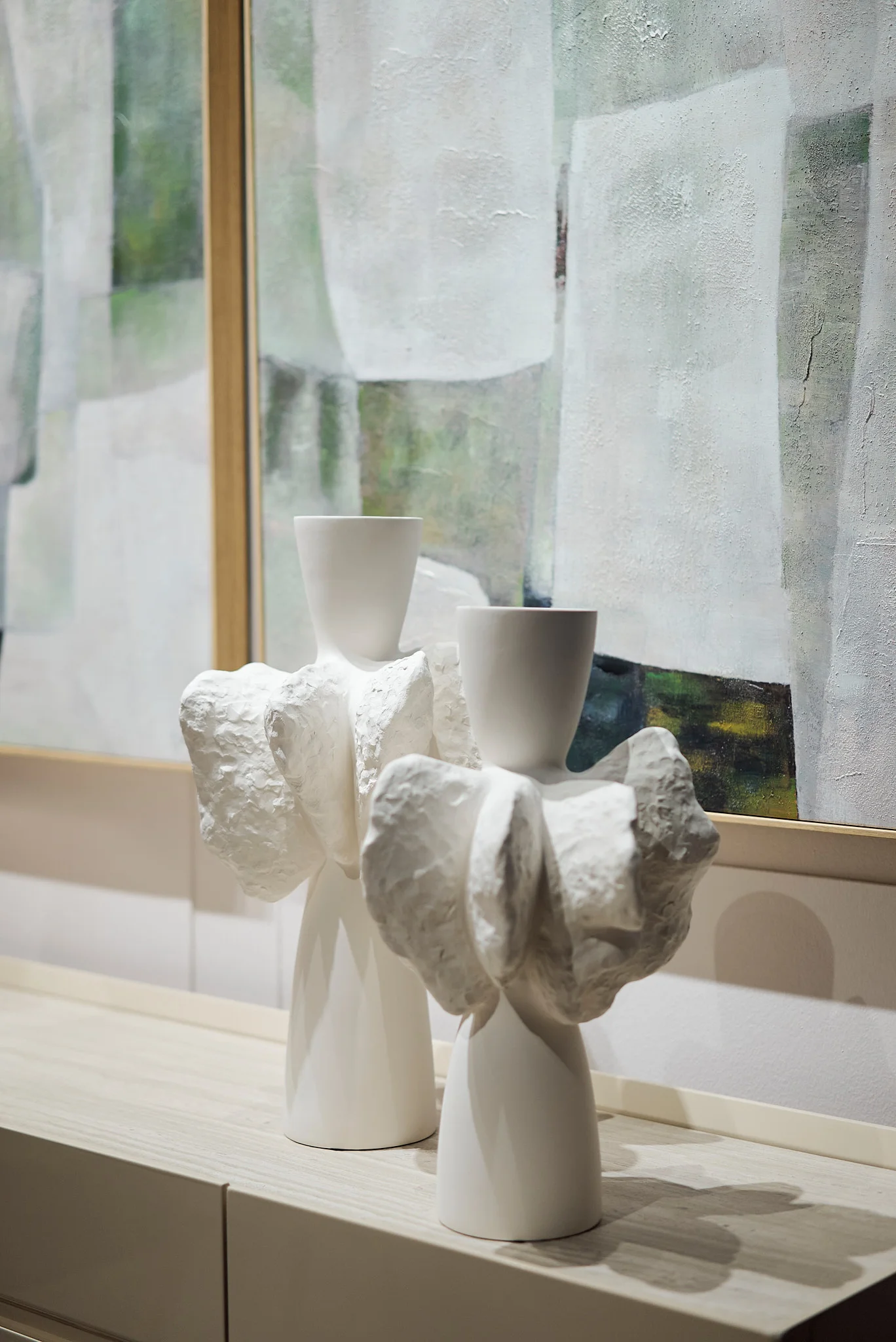 Pareja de esculturas cerámicas de color blanco con formas y volúmenes orgánicos artesanales.