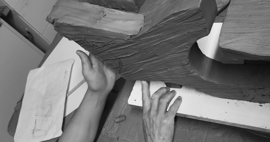 Proceso de elaboración de una escultura en cerámica en el taller de VP Interiorismo, mostrando el modelado manual de la arcilla con pruebas de formas, texturas y bocetos preliminares.